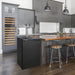 Black Kegco K309 Kegerator tucked beside a wood-topped kitchen island with bar stools and grey cabinets